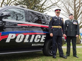 Bea Serdon/The Intelligencer 
Chief Ron Gignac of the Belleville Police Force and Captain Eric Rolfe of the Hastings and Prince Edward Regiment pose in front of the newly unveiled police cars that will have the support your troops yellow ribbon at the rear.