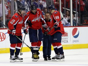 Alex Ovechkin of the Washington Capitals is helped off the ice by teammates during Game 5 against the Toronto Maple Leafs at Verizon Center on April 21, 2017. (Rob Carr/Getty Images)