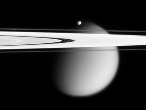 This image made by the Cassini spacecraft and provided by NASA on March 12, 2006, shows two of Saturn's moons, the small Epimetheus and smog-enshrouded Titan, with Saturn's A and F rings stretching across the frame. Launched in 1997, Cassini reached Saturn in 2004 and has been exploring it from orbit ever since. Cassini’s fuel tank is almost empty, so NASA has opted for a risky, but science-rich grand finale. (AP Photo/NASA)