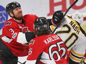 Senators defenceman Marc Methot (3) grimaces while in a scrum with Bruins' Riley Nash and Erik Karlsson moving during Game 5 of their Eastern Conference playoff series in Ottawa on Friday, April 21, 2017. (Wayne Cuddington/Postmedia)