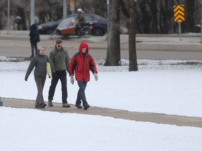 People walk along a sidewalk after snow fell in Winnipeg. Saturday, April 22, 2017. Chris Procaylo/WinnipegSun/Postmedia Network