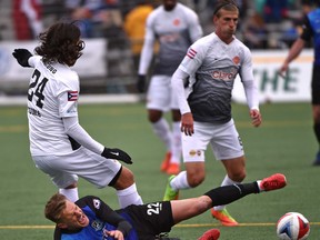 FC Edmonton Dean Shiels (22) gets tripped up by Puerto Rico FC Javier Monsalves known as Yuma (24) during NASL action at Clarke Stadium in Edmonton, April 22, 2017. Ed Kaiser/Postmedia