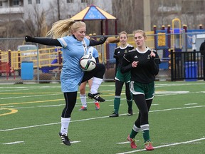 Christine Kettle, left, of St. Benedict Bears, cradles the soccer ball as Kayleigh Coufal, of Confederation Chargers, looks on during girls high school soccer action at James Jerome Sports Complex in Sudbury, Ont. on Friday April 21, 2017. The Chargers won 2-0. John Lappa/Sudbury Star/Postmedia Network