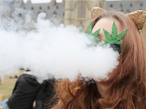 A woman smokes marijuana on Parliament Hill on 4/20 in Ottawa,  April 20, 2017. (LARS HAGBERG/AFP/Getty Images)