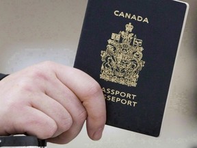 A passenger holds a Canadian passport before boarding a flight in Ottawa on Jan 23, 2007. The federal government has been quietly making changes to passport offices in a bid to improve security and address concerns that the facilities could be easy targets for a terrorist attack. THE CANADIAN PRESS/Tom Hanson