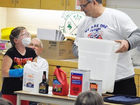 Brianna Cook (left), a Grade 5 student at Upper Thames Elementary School (UTES), assists Rotarian Bert Vorstenbosch, Jr. show the chemicals needed to create meth. ANDY BADER/MITCHELL ADVOCATE