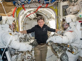 In this Jan. 13, 2017 file photo made available by NASA, astronaut Peggy Whitson, centre, floats inside the Quest airlock of the International Space Station with Thomas Pesquet, left, and Shane Kimbrough before their spacewalk.  (NASA via AP, File)