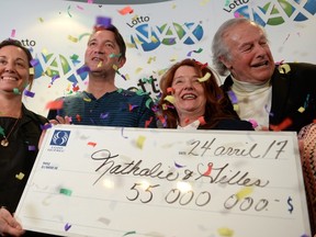Nathalie Langlais (second from right) and Gilles Rosnen (second from left) celebrate with family members as they hold their winning $55-million lottery cheque in Montreal, Monday, April 24, 2017. The couple hid the winning ticket in their daughter's toy box over the weekend.