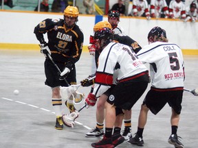 Wallaceburg Red Devils players Brendan Johnston and Tanner Cole fight for a loose ball against two Elora Mohawks players, during a game held at the Wallaceburg Memorial Arena on Saturday, April 22. The Red Devils won 7-5.
