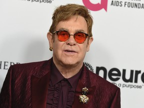In this March 25, 2017 file photo, Elton John arrives at Elton John's 70th Birthday and 50-Year Songwriting Partnership with Bernie Taupin celebration in Los Angeles. Elton John has cancelled more than a month of upcoming shows after contracting an “unusual” bacterial infection during a South America tour that left him in intensive care for two nights. The 70-year-old performer is expected to make a full recovery and hopes to return to a stage in Twickenham, England on June 3. (Photo by Jordan Strauss/Invision/AP, File)