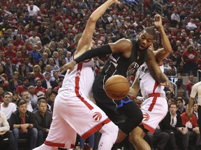 Raptors’ Jonas Valanciunas (left) and teammate Cory Joseph double-team Bucks centre Greg Monroe during the second quarter at the Air Canada Centre last night.  (Jack Boland/Postmedia Network)