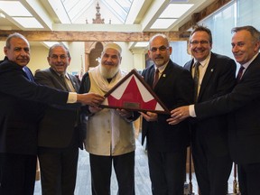 Bea Serdon/Special to The Intelligencer
Jerry Saleh, Coun. Garnet Thompson, Imam Mohammed Saleh, Mayor Taso Christopher, Coun. Egerton Boyce and MP Neil Ellis pose with the flag that was flown at half-mast during Belleville's February 2 vigil. The flag will be presented to citizens of Quebec City through MP Joel Lightbound.