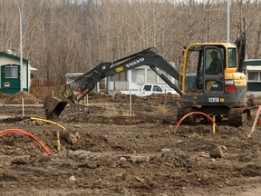 A worker uses an excavator while working the Waterways neighbourhood of Fort McMurray on Thursday, April 6, 2017. Ian Kucerak / Postmedia