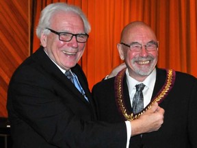 Rideau Lakes Mayor Ron Holman, who was leaving office as warden of Leeds-Grenville, gives the warden's chain to his successor, North Grenville Mayor David Gordon, in December 2014. NICK GARDINER / POSTMEDIA NETWORK