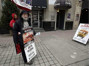 A protester stands on Bank St. just outside The Morgentaler Clinic on Monday December 07, 2015. Darren Brown / Postmedia