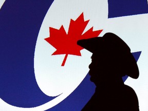 A forum visitor is silhoutetted in front of a projected logo before a Conservative party leadership candidate forum at the Deerfoot Inn and Casino in Calgary, Alta. on Wednesday March 1, 2017. (Jim Wells/Postmedia Network)