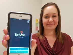 Jessica Ross, youth engagement facilitator with the Oxford-Elgin Child & Youth Centre, holds out a phone with the Be Safe app installed on it. The app is meant as a go-to resource hub for youth who need to connect to mental health and/or addiction services. (Laura Broadley/Times-Journal)