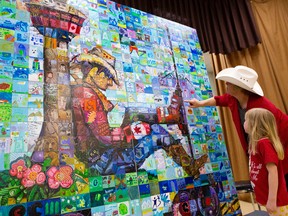 Karen Bishop and Allison Lento, 6, look for the piece that she painted on the Woodlands School Canada 150 Mosaic that was unveiled at the school in Calgary, Alta., on Thursday April 6, 2017. Leah Hennel/Postmedia