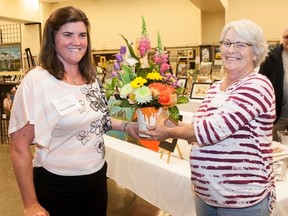 Favourite Artist recipient Christine Hasenhundl accepts a bouquet from Featured Artist Sandra Miller at the Vermilion Art Club’s seventh annual Spring Art Show and Sale on Saturday, April 22. Taylor Hermiston/Vermilion Standard/Postmedia Network.