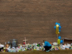 A woman cries at the memorial for 19-month-old Anthony Raine at Good Shepherd Anglican Church, 15495 Castle Downs Road on Tuesday. (DAVID BLOOM)