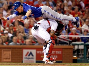 Toronto Blue Jays' Chris Coghlan leaps over St. Louis Cardinals catcher Yadier Molina to score during the seventh inning of a baseball game Tuesday, April 25, 2017, in St. Louis. (AP Photo/Jeff Roberson)