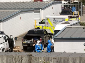 London police get put into hazmat suits before entering a suspected drug lab in a storage unit at StorageMart on Commissions Road in London, Ont. Photograph taken on Wednesday April 26, 2017. Mike Hensen/The London Free Press/Postmedia Network