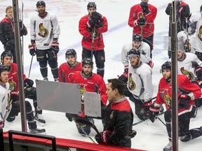 Head coach Guy Boucher draws up a drill as the team pays close attention during Ottawa Senators practice at the Canadian Tire Centre on April 26, 2017. (Wayne Cuddington/Postmedia)
