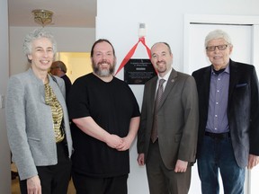 Caroline Davis, United Way's board chair, left to right, Jason Beaubiah, executive director of Kingston Youth Shelter, Kingston Mayor Bryan Paterson and Ian Henderson of Kingston Housing stand beside the plaque dedicated to Britton Smith, who donated $1.2 million to the project. (Gracie Postma, The Whig-Standard)