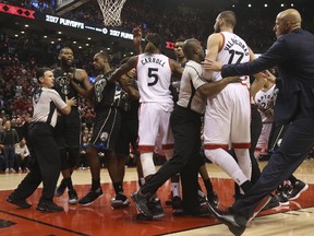 Toronto Raptors centre Jonas Valanciunas objects to having his arm wrenched by Milwaukee Bucks guard Khris Middleton and starts a scuffle during Game 4 on April 25, 2017. (Jack Boland/Toronto Sun/Postmedia Network)