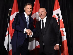 Conservative Party leadership candidate Maxime Bernier (left) shakes hands with Kevin O'Leary at a news conference in Toronto, Wednesday, April 26, 2017, after it was announced that O'Leary had quit the leadership race and thrown his support behind Bernier. (THE CANADIAN PRESS/Nathan Denette)