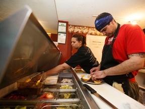 (Left to right) Cat Hare and Owen Erskine work the sandwich counter on a busy Saturday at Mitchell's Cafe in Fort McMurray on Saturday, April 8, 2017. Cafe owner Erkine spoke to the successes and challenges of business in the city post fire. Ian Kucerak / Postmedia