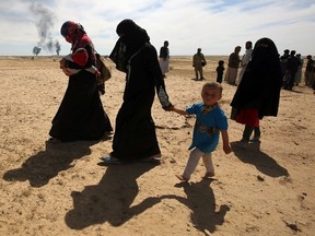 Displaced Iraqi families evacuate from the modern town of Hatra and neighbouring villages, near the eponymous UNESCO-listed ancient city, southwest of the northern city of Mosul, on April 26, 2017, as pro-government Hashed al-Shaabi (Popular Mobilization) paramilitary forces advance during an offensive to retake the area from Islamic State (IS) group fighters. Hatra is the latest important archeological site to be recaptured from IS. Jihadists had embarked on a campaign of destruction against archeological sites after they seized swathes of Iraq and Syria in a lightning 2014 offensive. (AHMAD AL-RUBAYE/Getty Images)