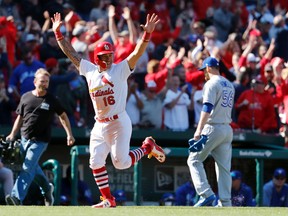 St. Louis Cardinals' Kolten Wong jogs in to score as Toronto Blue Jays relief pitcher J.P. Howell walks off the field following a walk-off grand slam by Matt Carpenter in the 11th inning on April 27, 2017, in St. Louis. (AP Photo/Jeff Roberson)