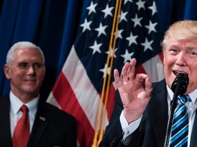 US Vice President Mike Pence (L) listens while US President Donald Trump speaks before signing an executive order at the US Department of Veterans Affairs April 27, 2017 in Washington, DC. (BRENDAN SMIALOWSKI/AFP/Getty Images)