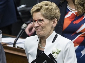 Premier Wynne leaves holding the budget after the reading of the budget at Queens Park on Thursday April 27, 2017. (Craig Robertson/Toronto Sun)