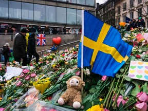 People gather at a makeshift memorial to commemorate the victims of last Friday's terror attack near the site where a truck drove into Ahlens department store in Stockholm, on April 14, 2017. Four people died and fifteen were injured when a truck plunged into a crowd at a busy pedestrian street in the Swedish capital on April 7, 2017. / AFP PHOTO
