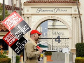 In this Jan. 23, 2008 file photo, striking film and television writers picket outside Paramount Studios in Los Angeles. Hollywood is facing a cliffhanger after members of the Writers Guild of America voted overwhelmingly to authorize a strike that could begin as soon as May 2, the day after the current contract ends. The previous writers’ strike lasted 100 days in 2007-08 and was costly to the businesses that serve Hollywood and to consumers expecting to be entertained. (AP Photo/Kevork Djansezian, File)
