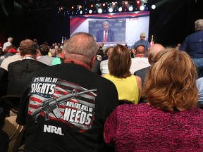 NRA attendees Bill and Karen Geittman watch a video of U.S. President Donald Trump while waiting for him to arrive for a keynote at the NRA-ILA Leadership Forum in Atlanta on Friday, April 28, 2017. (Curtis Compton/Atlanta Journal-Constitution via AP)