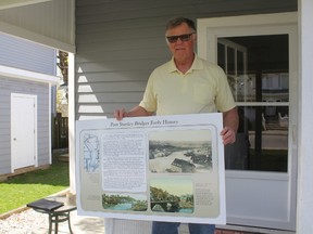 John Morrow, a member of Heritage Port Stanley, holds up a sign similar to the ones his group is proposing to be put around the harbour. This sign was made by Andrew Hibbert for another project. (Laura Broadley/Times-Journal)