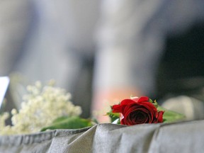 Roses are laid on the tables in remembrance at the National Day of Mourning event to commemorate workers who have been killed, injured or suffered an illness due to a workplace-related hazard or incident. (Steph Crosier/The Whig-Standard)