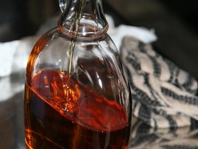 Maple syrup is poured into a glass bottle. (Postmedia Network/Files)