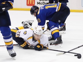 Nashville Predators right wing Miikka Salomaki (20), of Finland, reaches for the puck after falling on the stick of St. Louis Blues right wing Scottie Upshall (10) during the third period in Game 2 of an NHL hockey second-round playoff series Friday, April 28, 2017, in St. Louis. (AP Photo/Jeff Roberson)