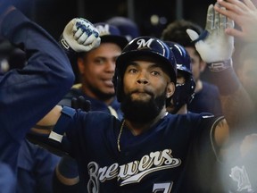 Eric Thames gets high-fives in the Brewers dugout following one of his 11 April home runs. (Morry Gash, AP)