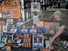 Deborah Hines of Audrey's Books on Jasper Avenue adjusts some of the items in an Oilers window display with books and Orange soda pop  on April 26,  2017.  Photo by Shaughn Butts / Postmedia