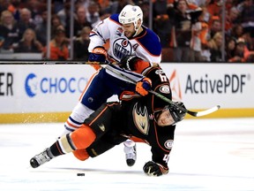 Cam Fowler #4 of the Anaheim Ducks is pushed to the ice by Milan Lucic #27 of the Edmonton Oilers during the third period of Game Two of the Western Conference Second Round during the 2017  NHL Stanley Cup Playoffs at Honda Center on April 28, 2017 in Anaheim, California.