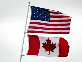 Canadian and American flags fly in Point Roberts, Wash., on Tuesday March 13, 2012. Canada, the next-door neighbour known for its socialized medicine, liberal social policy, and aversion to the Iraq war is now perceived through a slightly different prism: big oil, small corporate taxes, and hawkish rhetoric against Putin and ISIL.THE CANADIAN PRESS/Darryl Dyck