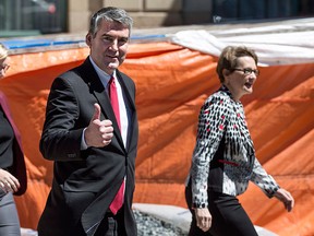 Nova Scotia Premier Stephen McNeil, centre, gestures toward reporters while leaving Government House with his daughter Colleen, left, and wife Andre after asking the Lieutenant Governor to dissolve the House in order to call a provincial election in Halifax on Sunday, April 30, 2017. THE CANADIAN PRESS/Darren Calabrese