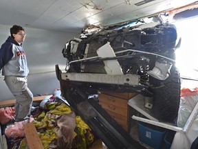 Standing on his bed, Kyle Roach looks at a pickup truck that crashed into his basement suite almost landing on him while he was sleeping around 8 a.m. on April 30, 2017.
