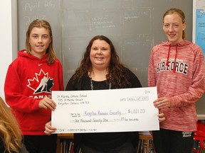 Student representatives from Paul Coulter’s Grade 7/8 class at St. Martha Catholic School — Nathan McCormick and Aaliyah Donnelly — on Wednesday present Kingston Humane Society volunteer event co-ordinator Tanya Wilson a cheque for $1,021.20 that the class raised for its almsgiving project. (Julia McKay/The Whig-Standard)