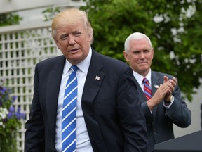 U.S Vice-President Mike Pence (R) applauds U.S. President Donald Trump during an event for the Independent Community Bankers Association in the Kennedy Garden of the the White House on May 1, 2017 in Washington, D.C. (ANDEL NGAN/AFP/Getty Images)